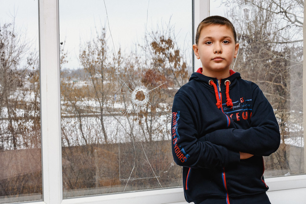 Ukraine Boy Stands Next To Bullet Hole In Window At School In Donetsk