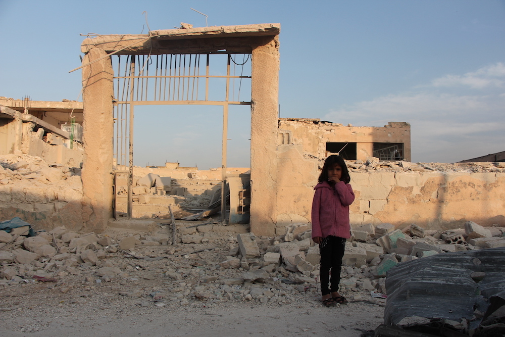 Baraa Aged Seven Stands In Front Of Her Damaged School In Idlib