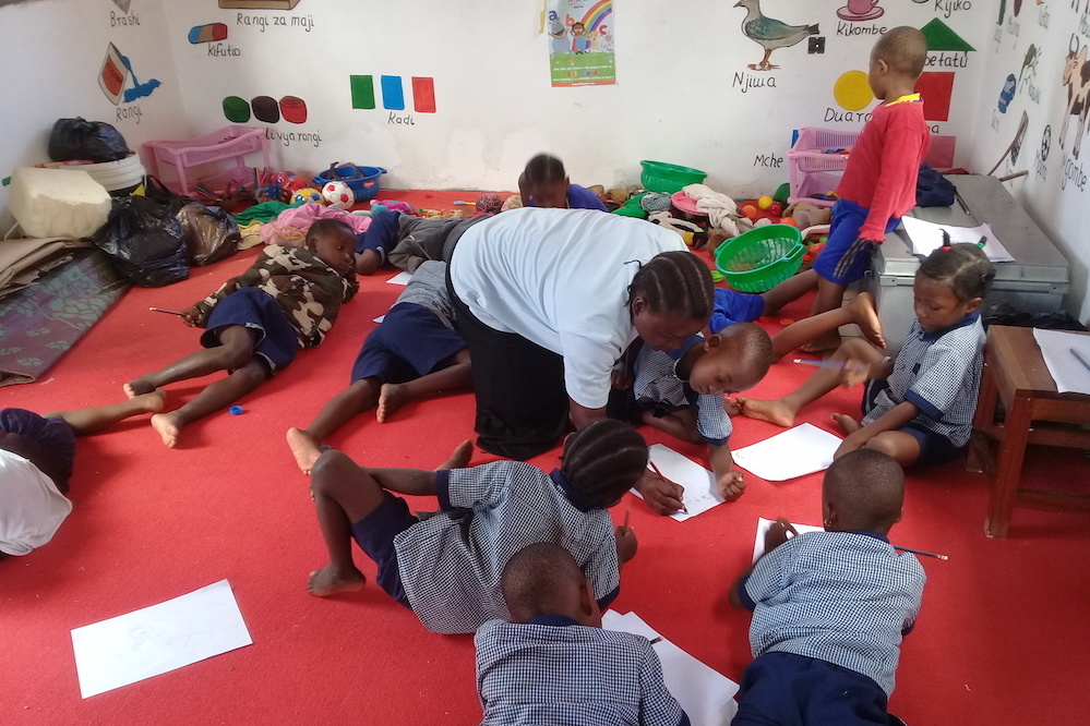 The Play Leader At The Brac Play Lan At Kidaga Tanzania Helps Children With Their Drawing