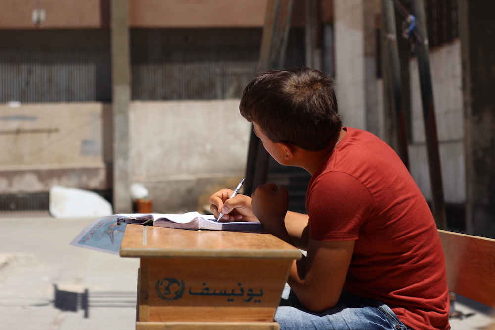 Syrian Boy Studies Outside A Learning Centre In Aleppo