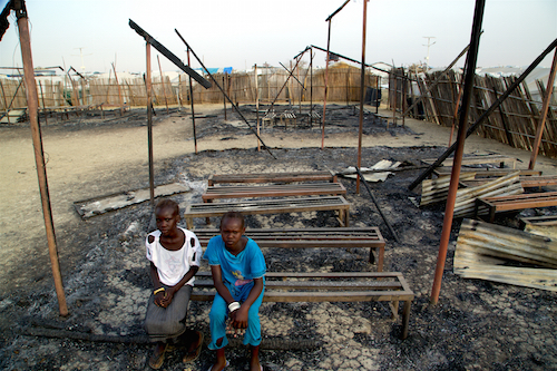 Children sit in the burned ruins of school in Malaka, South Sudan, that was destroyed in fighting in February Picture: UNICEF/George