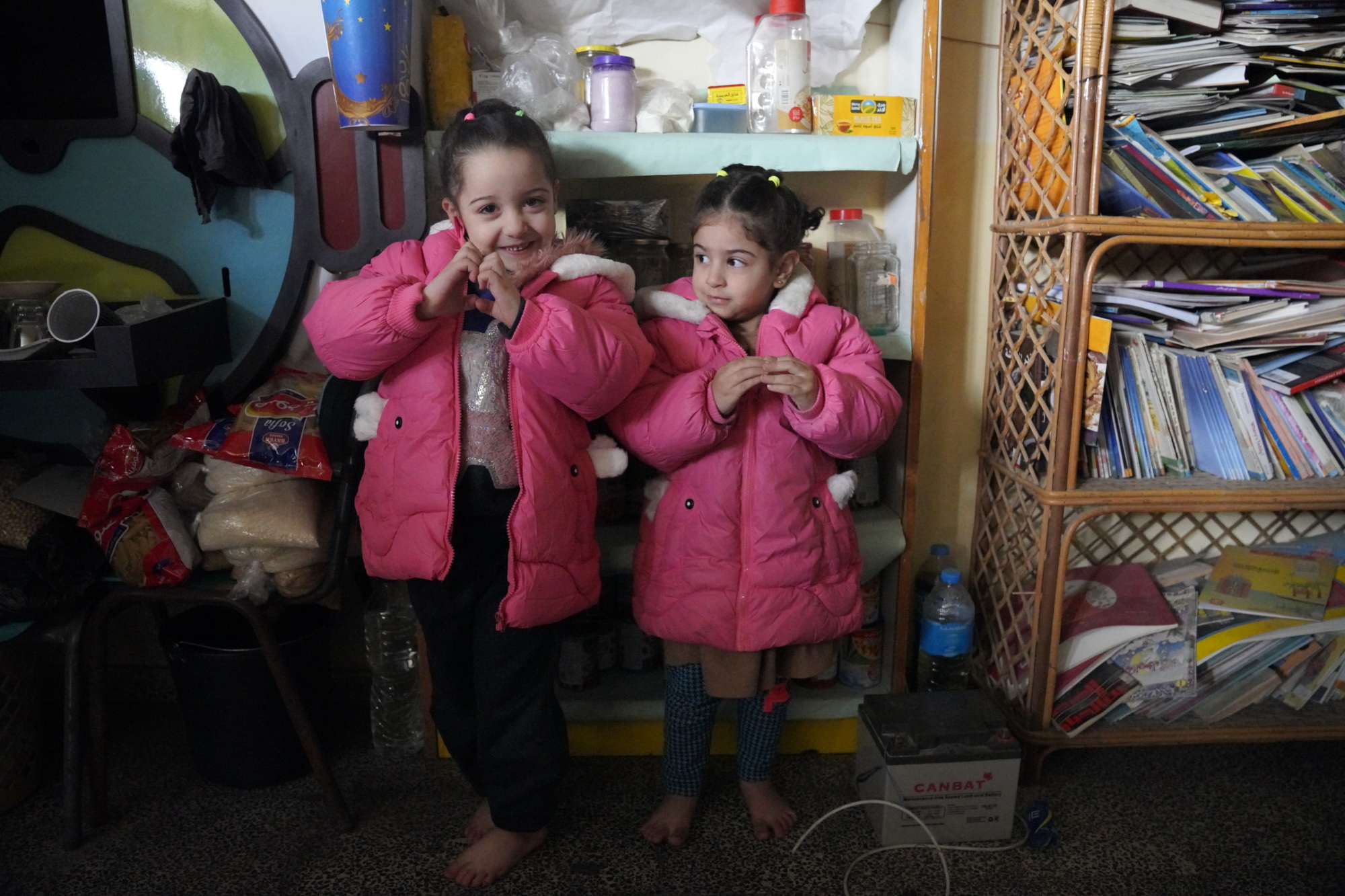 Four-year-old Jalila and three-year-old Suha in warm winter jackets at a women's centre in Gaza that is being used as a shelter (UNICEF/Ingram)