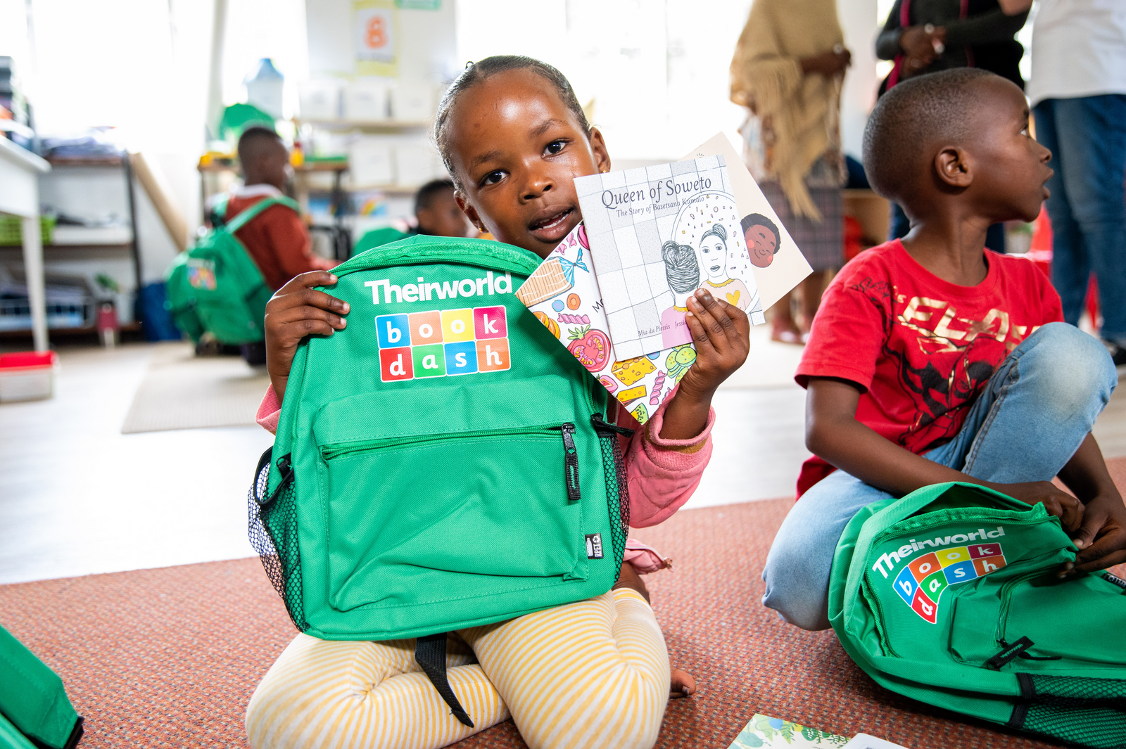 A little girl holding up her book.