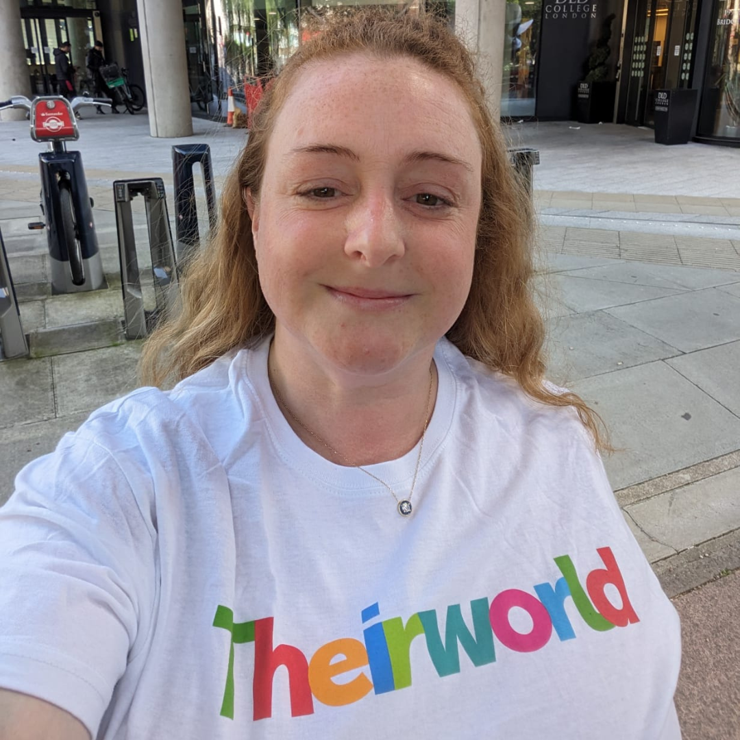 A person wearing a Theirworld t-shirt